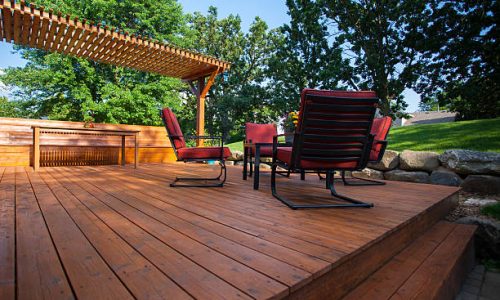 Backyard deck with deck chairs and a pergola on a sunny summer day. Backyard deck with deck chairs and a pergola on a sunny summer day.