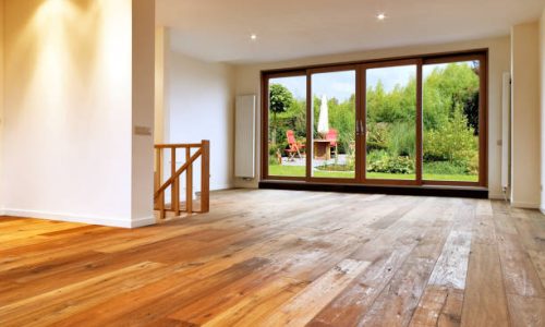 Wooden Door and Frames3 Empty big living room interior with wooden floor. Dining table with chairs ,parasol in a lush garden outside, there is a path for the windows